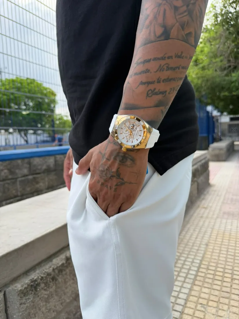 Modelo con un reloj blanco y dorado